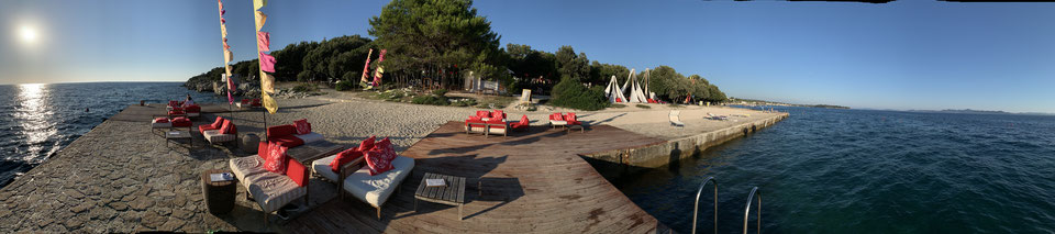 El nuevo club de playa Punta Skala con muebles de salón frente al mar al atardecer