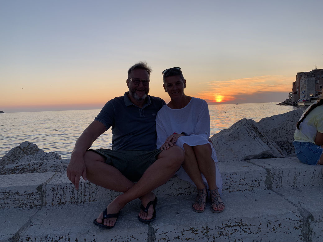 Torgit und Marc sitzen auf der Kaimauer von Rovinj vor dem Sonnenuntergang