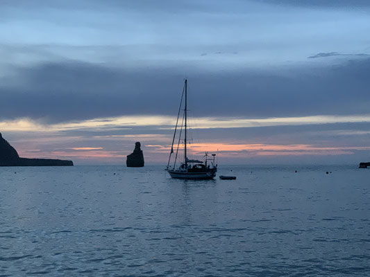 Segelboot kurz nach Sonnenuntergang in der Bucht Beniras, ibiza
