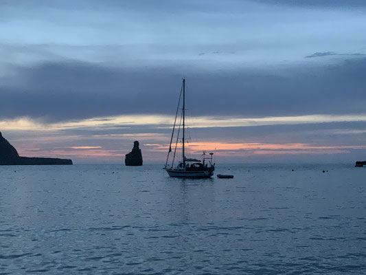 Sailing boat shortly after sunset in the bay of Beniras, ibiza