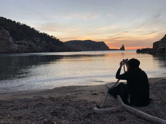 Hippie drummer photographing heart stone in the bay of Benirrás