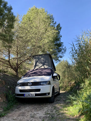 VW California blanche garée dans le lit d'une rivière à IBIZA