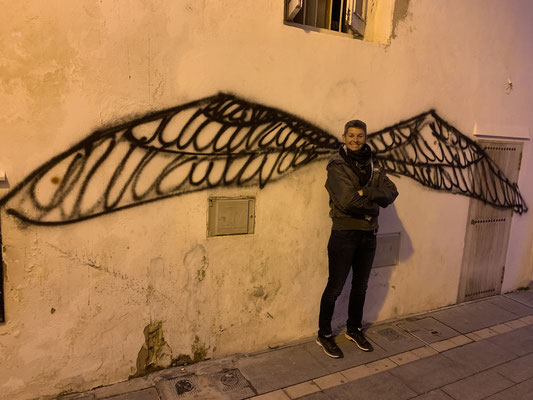 Torgit stahlend vor Grafitti in Ibiza Altstadt
