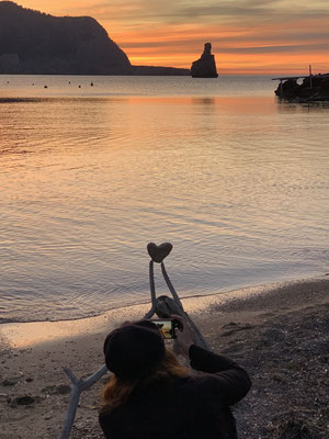Hippie drummer photographing heart stone in the bay of Benirrás