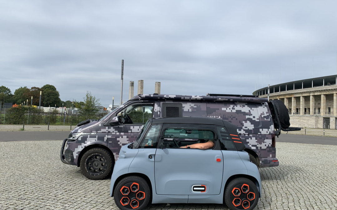 Marc, im neuen, glaublauen Elektromobil Citroen Ami, vor dem Olympiastadion Berlin