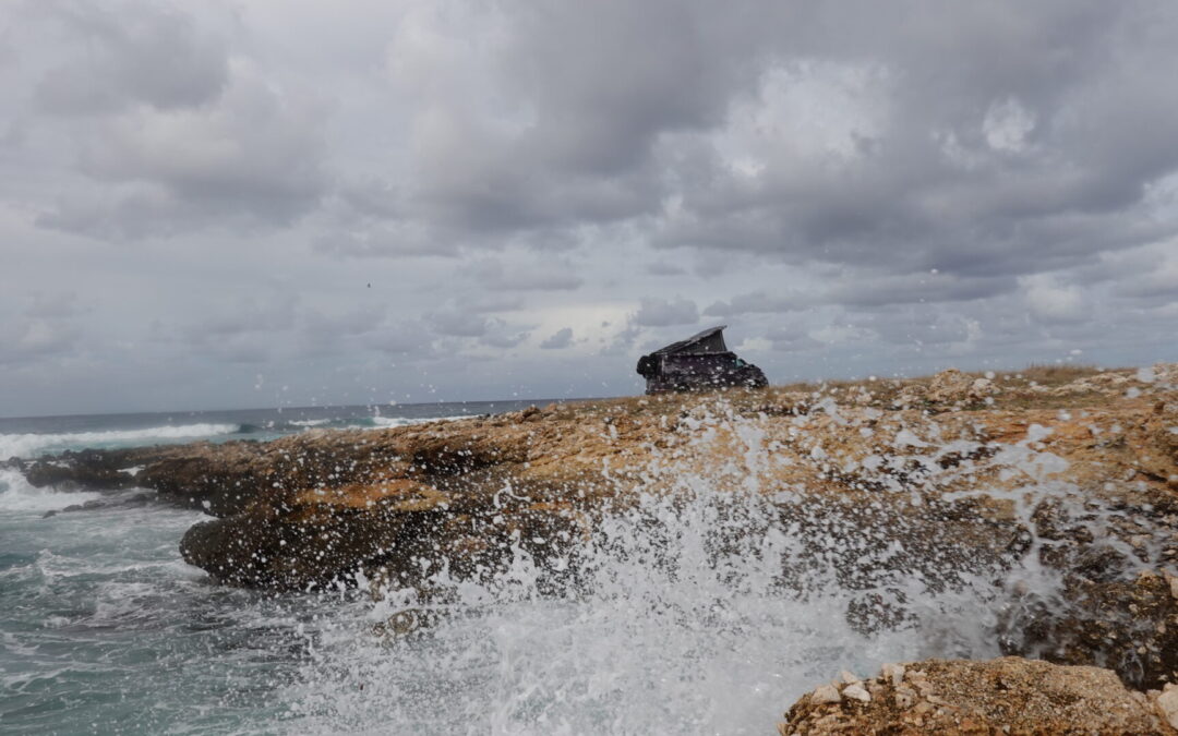 Foaming waves in front of the planBwagen on a cliff by the sea, VW T6.1 SpaceCamper, with Terranger conversion and delta 4x4 rims