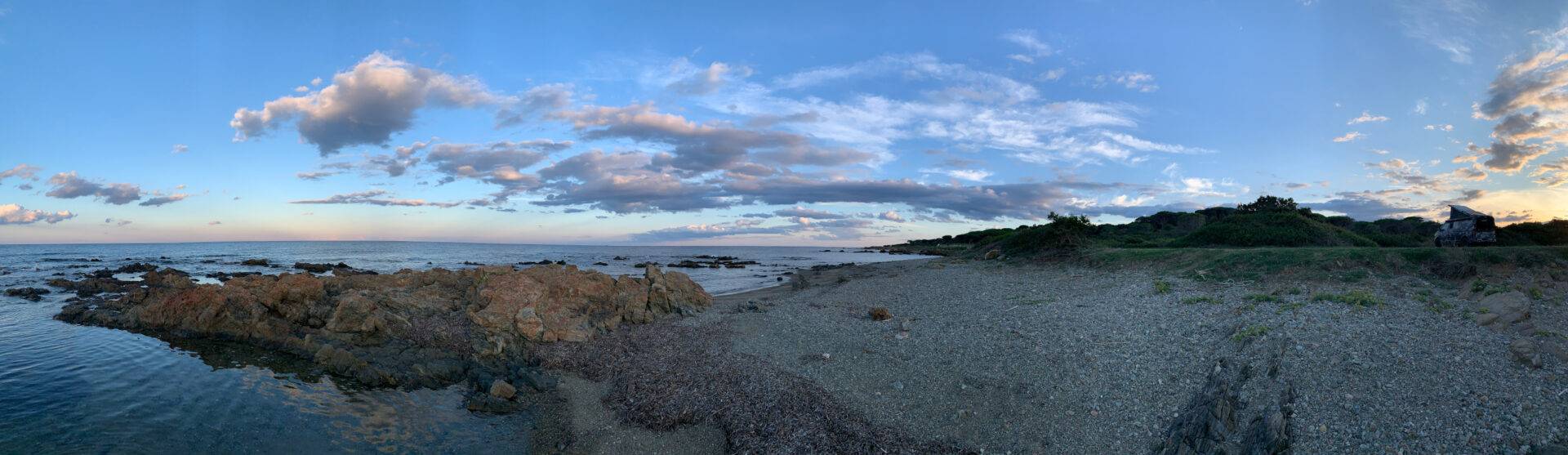 Ambiance de soirée sur la plage au nord de Baia Sant&#039 ; Anna, Sardaigne, en arrière-plan le camouflage planBwagen, T6.1 SpaceCamper avec arceau de sécurité Delta4x4 et jante Klassik_B