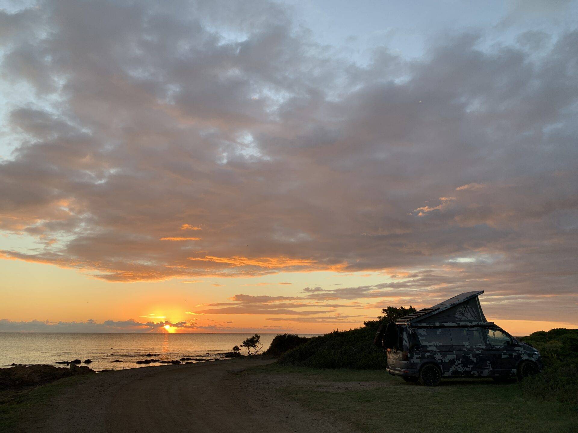 Sole nascente Sulla spiaggia a nord di Baia Sant'Anna, piano mimeticoBwagen, T6.1 SpaceCamper con barra di protezione personale Delta4x4 e cerchione Klassik_B