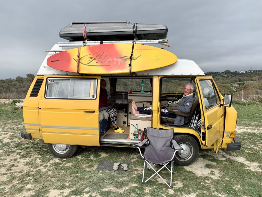 gelbe VW T4 mit Hochdach und Surfbrett