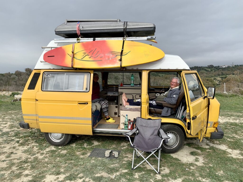 VW T4 giallo con tetto alto e tavola da surf