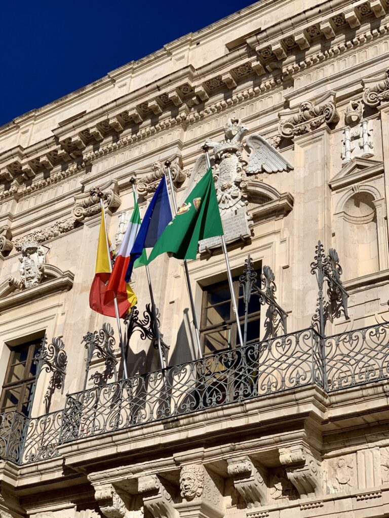 Drapeaux sur un palais baroque à Syracuse