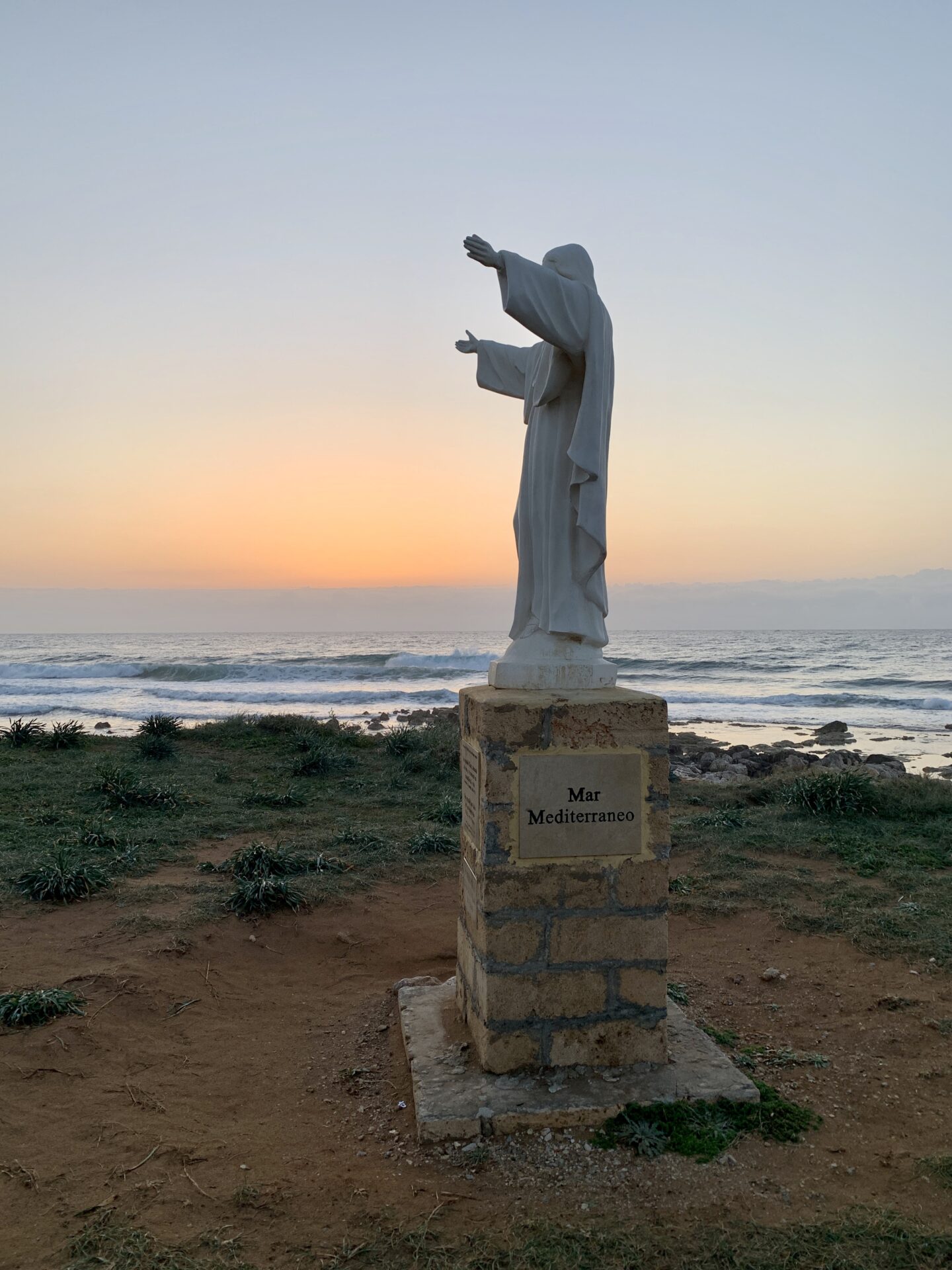 La statua di Christo davanti all'Isola delle Correnti al sorgere del sole