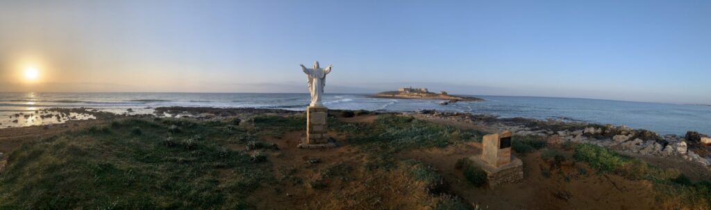 La statua di Christo davanti all'Isola delle Correnti al sorgere del sole