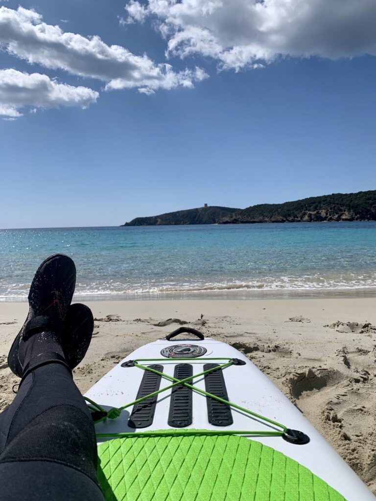 Füße auf SUP am Strand auf Sardinien